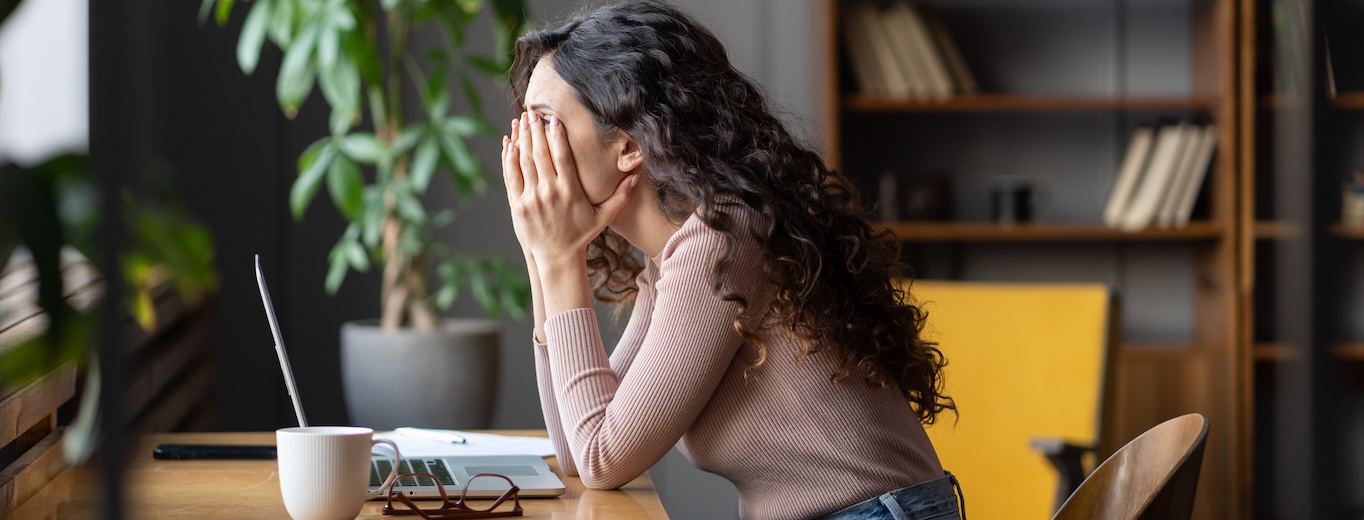 Müde bei der Arbeit Buehne Erschöpfte Frau stützt den Kopf in den Händen – müde bei der Arbeit im Büro